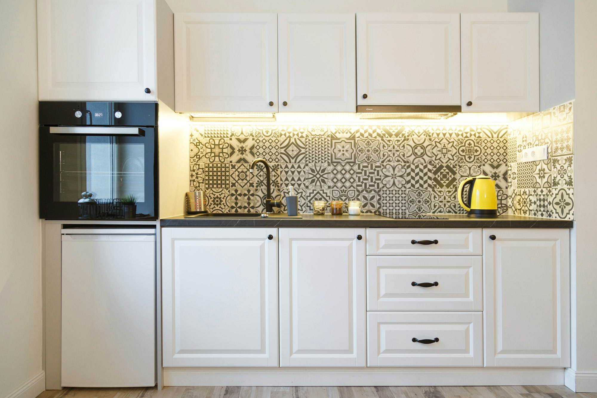 Beautiful home kitchen with white cabinets and backlight