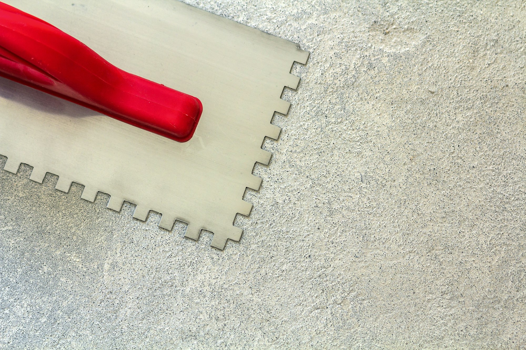 Construction notched trowel is a tool for tiles installation work