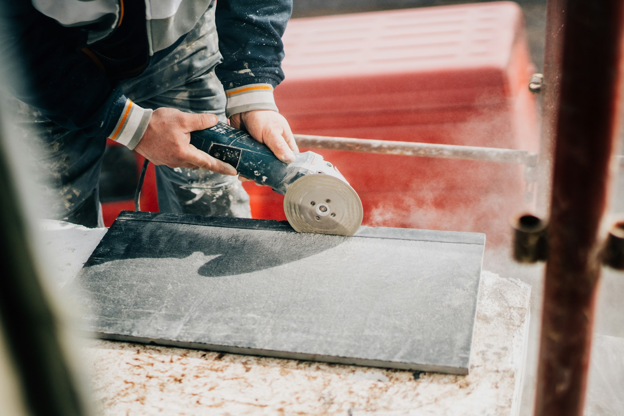 Details of worker cutting stone marble with angle grinder at construction site