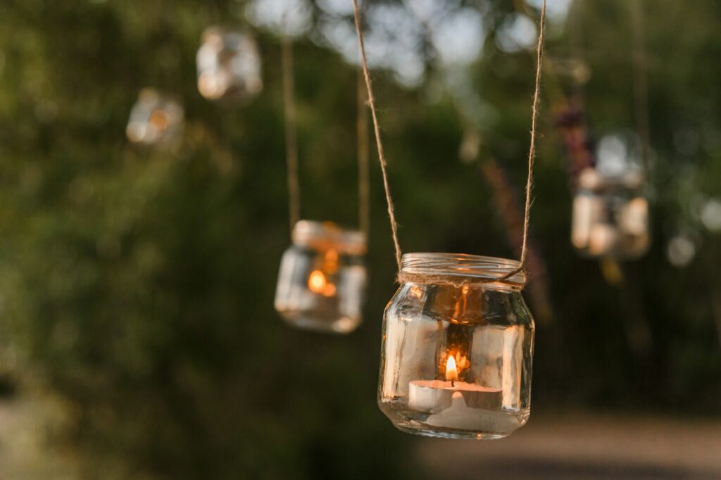 Mason jar candle hanging on tree for wedding decor