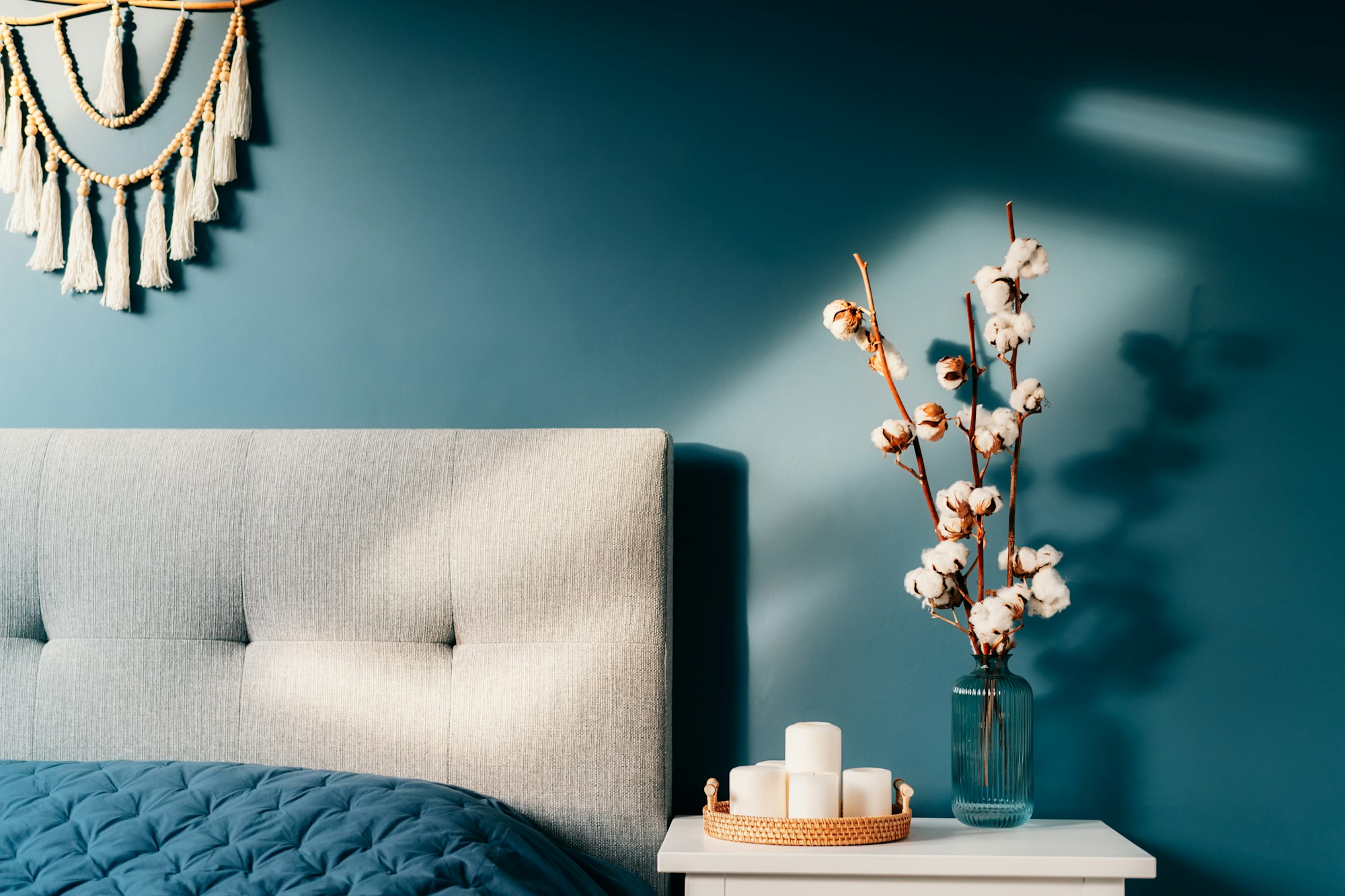 Stylish modern bedroom in dark colors. Cozy interior with navy blue walls, home decor.