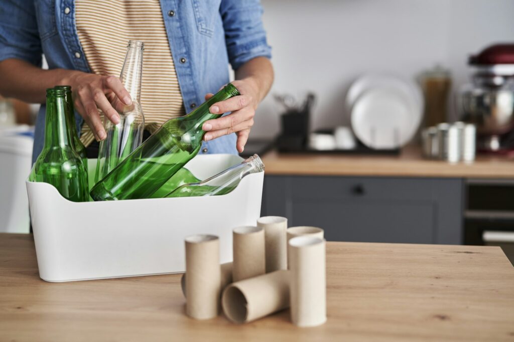 Woman recycling glass garbage in the kitchen