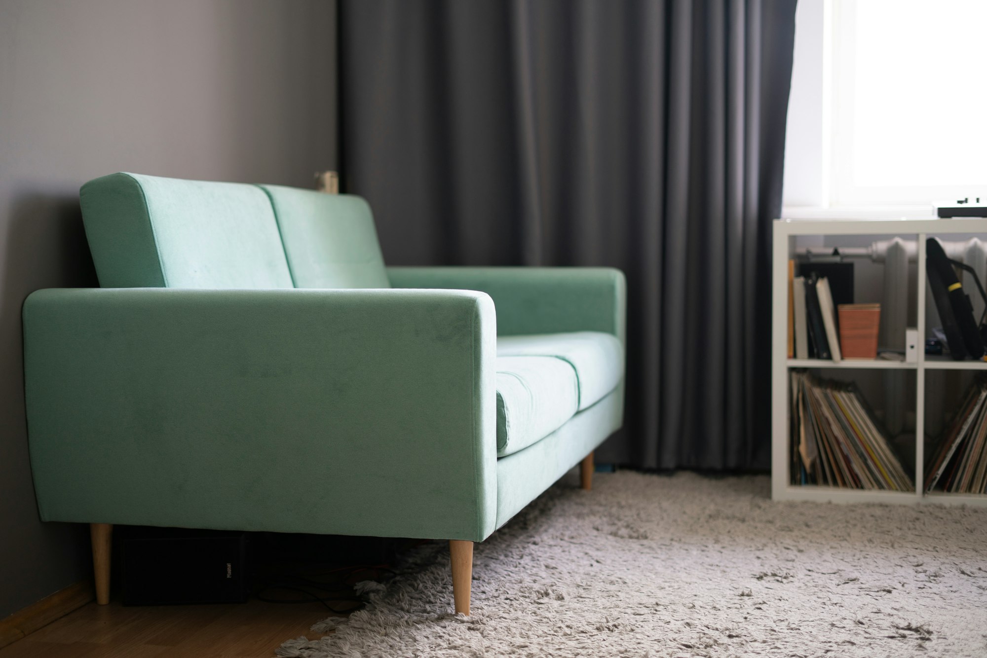 a simple light grey sofa couch at home, minimalistic apartment style