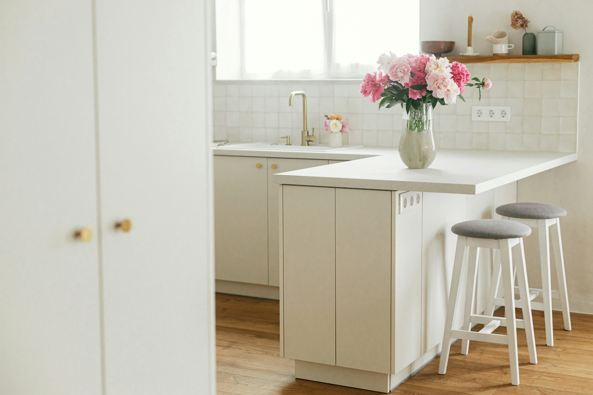 Beautiful peonies in vase on granite countertop island