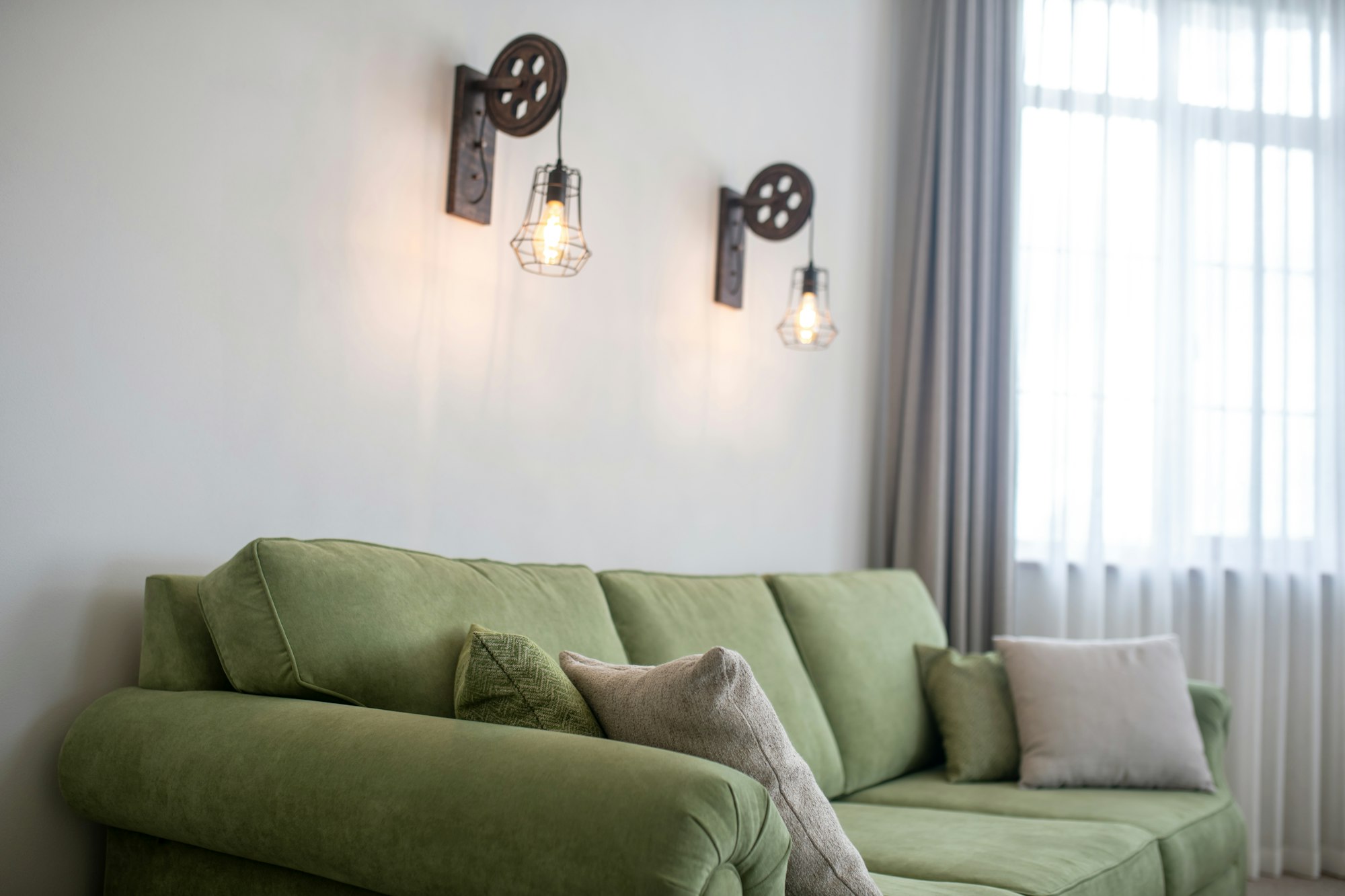 Wall-mounted lighting fixtures and a cozy velvet couch