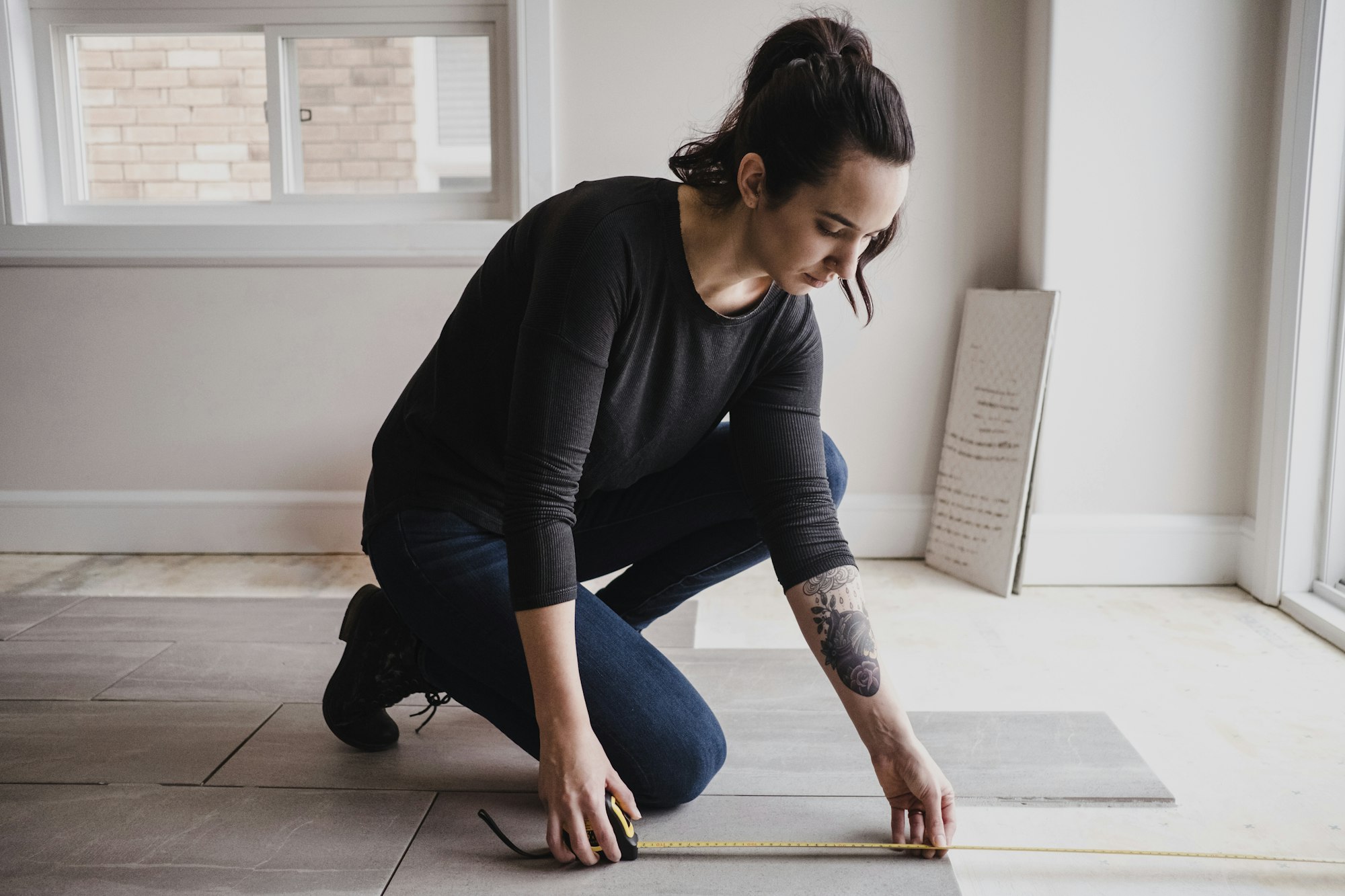 Woman measuring floor tiles