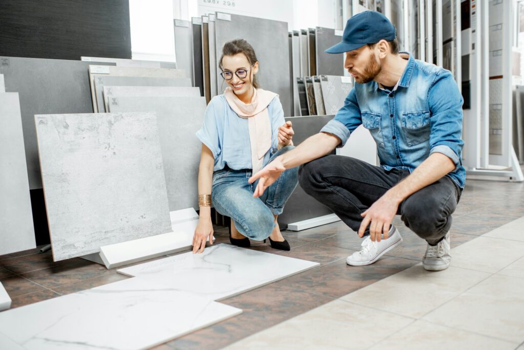 Woman with salesman in the shop with ceramic tiles